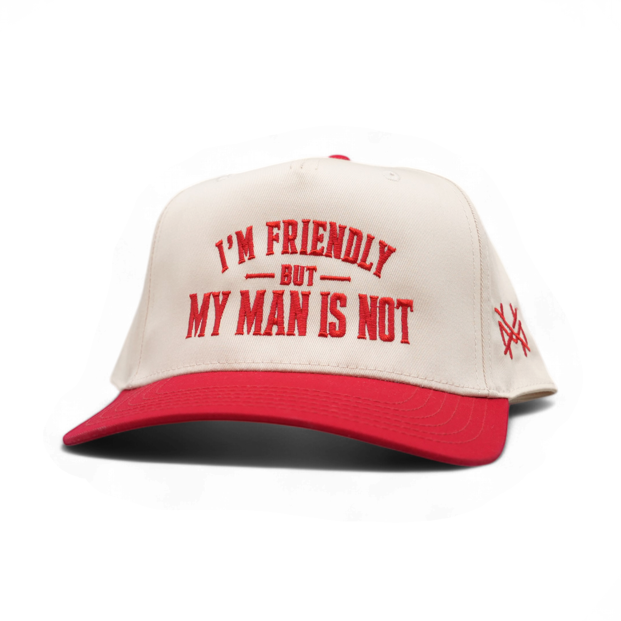 A red and off-white snapback cap with the text 'I'M FRIENDLY BUT MY MAN IS NOT' embroidered in red on the front, and a small red embroidered logo on the side, shown on a white background.