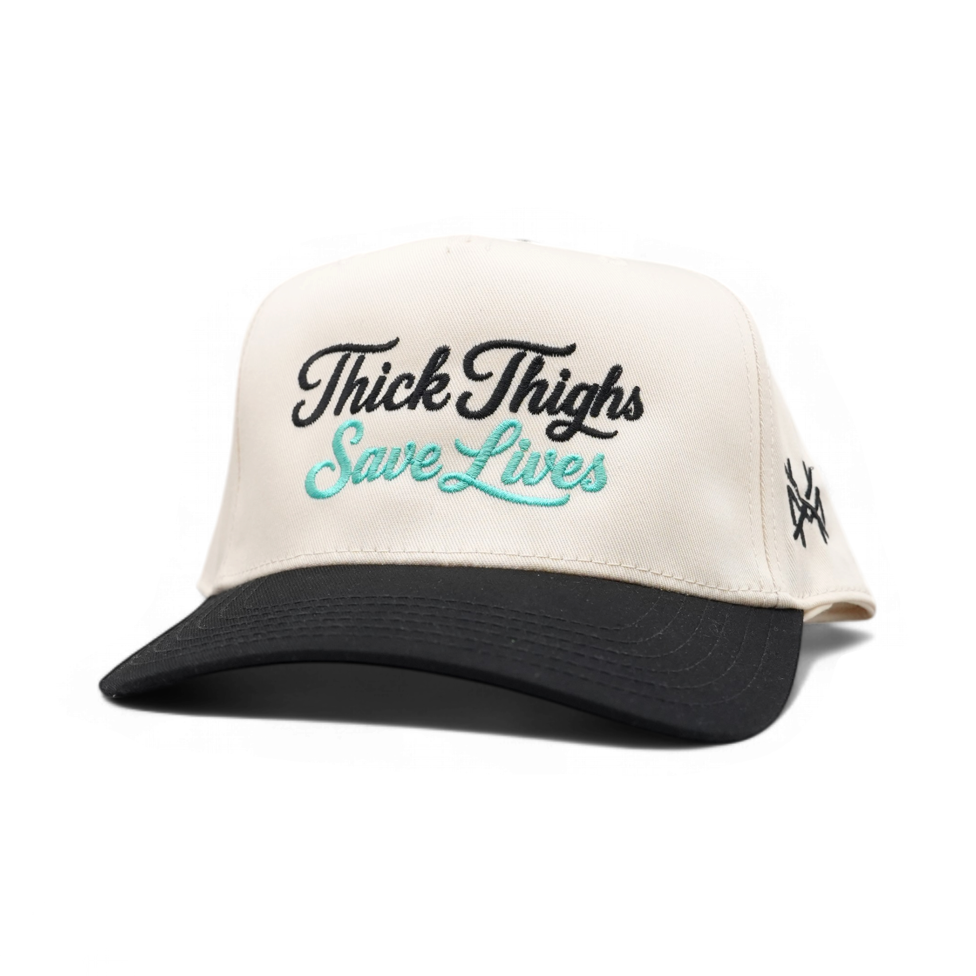 An off-white and black trucker-style cap with 'Thick Thigs Save Lives' embroidered on the front, featuring a black brim and black side embroidery, set against a plain white background.