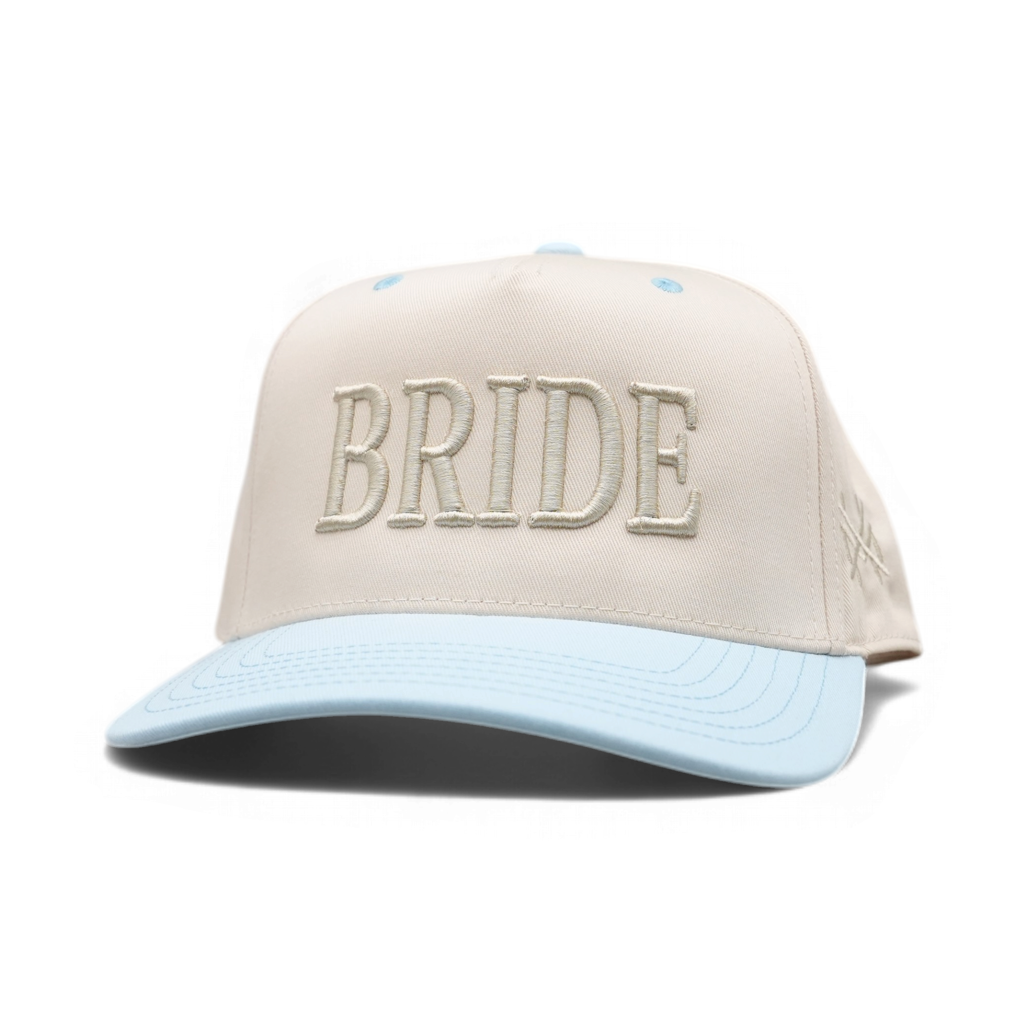 A structured baseball cap with a cream-colored crown featuring 'BRIDE' embroidered in light beige letters, and a light blue curved brim.