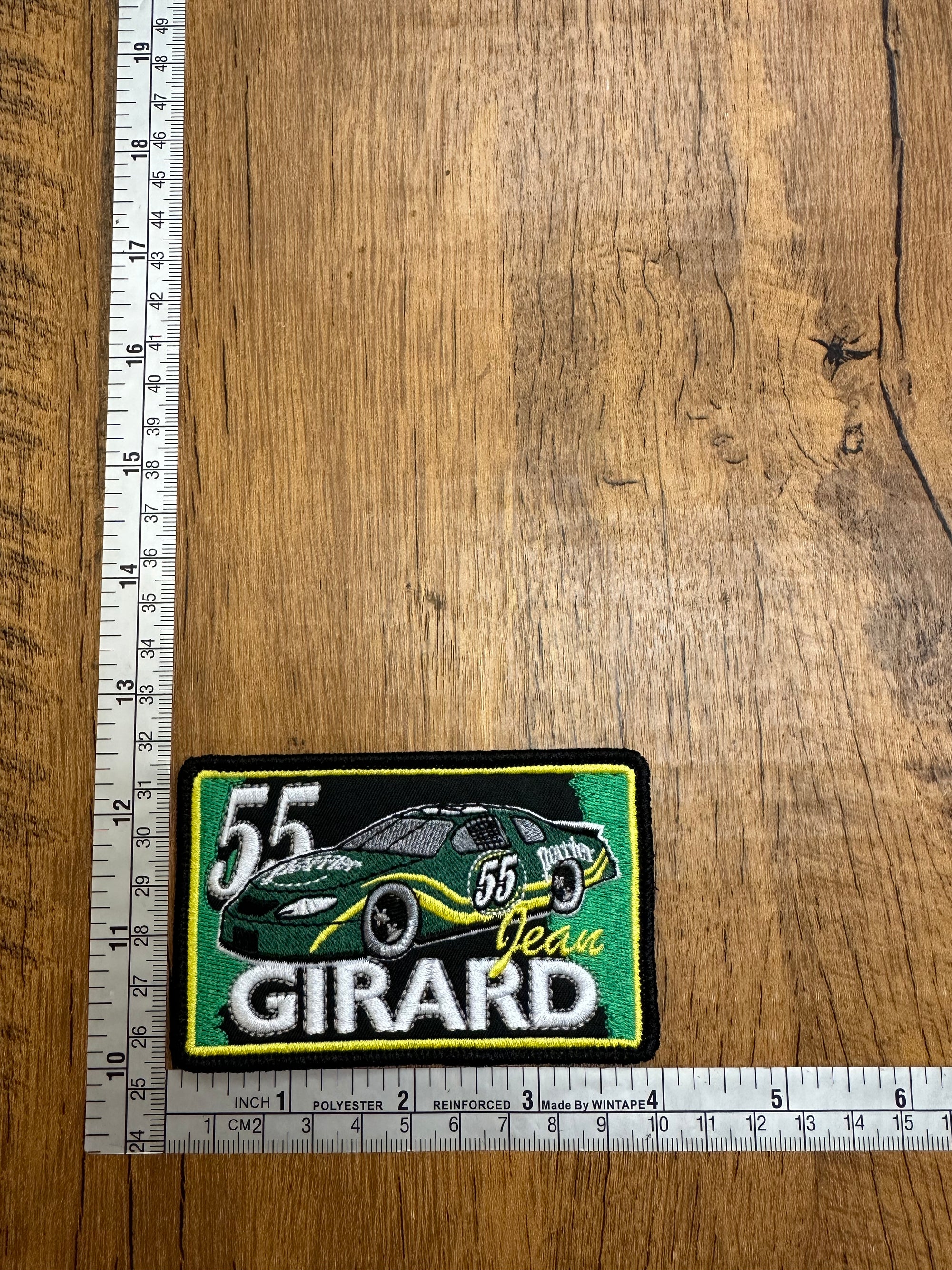 Close-up of the 55 Team Girard patch by The Mad Hatter Company, featuring embroidered design and vibrant colors.