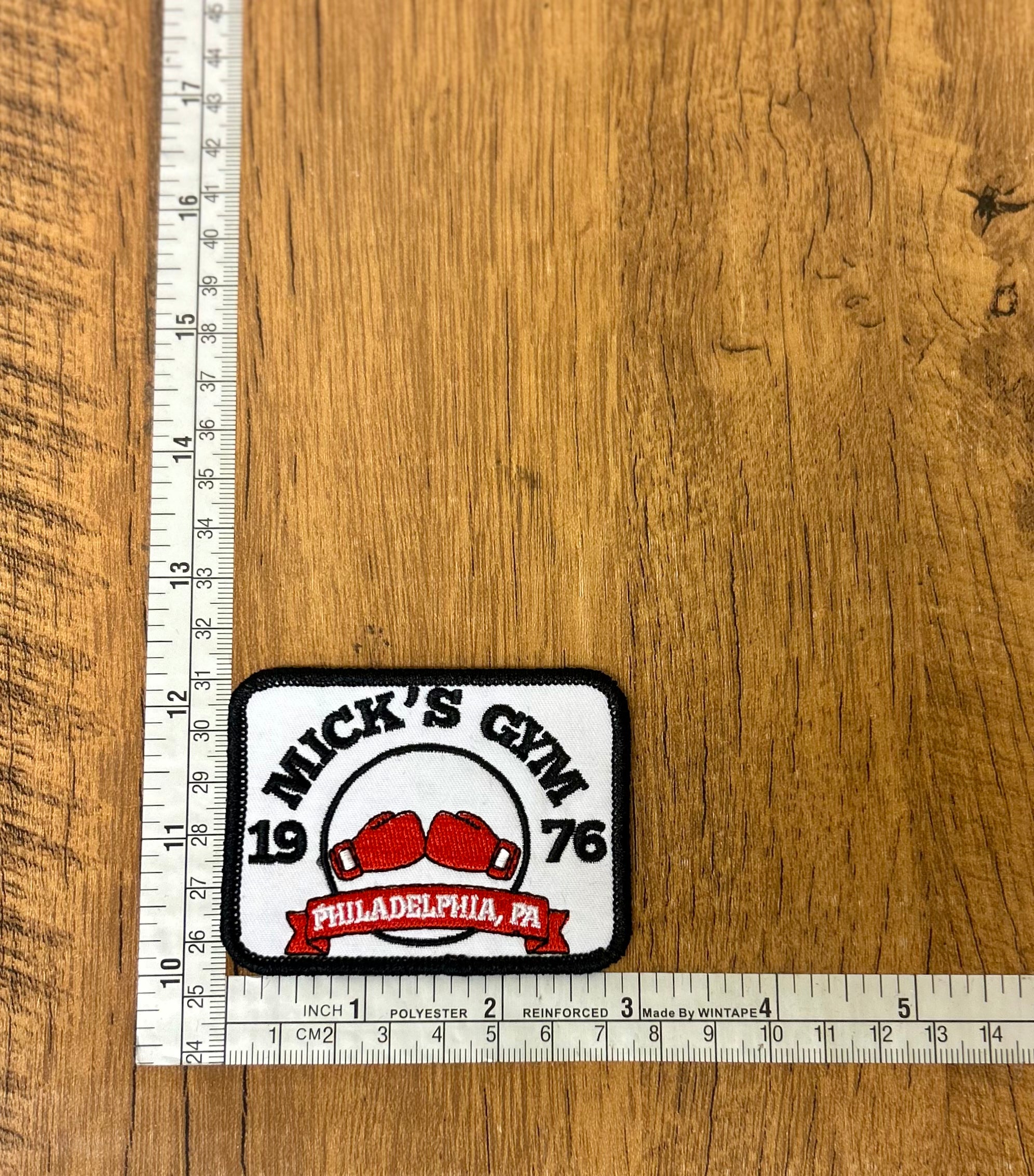 Mick's Gym patch by The Mad Hatter Company featuring a colorful embroidered design on fabric.