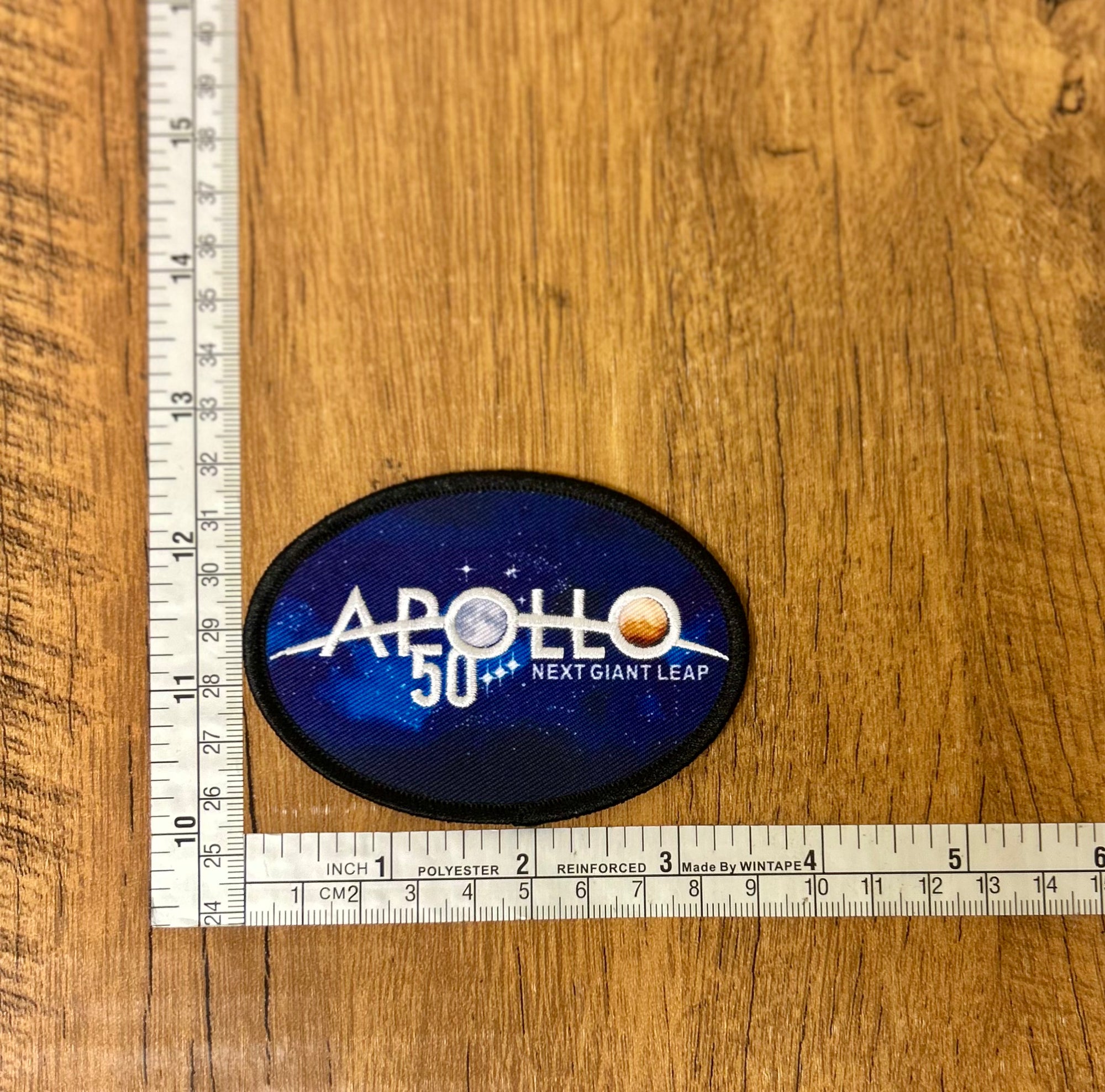 Apollo 50 patch by The Mad Hatter Company, featuring a colorful space-themed design on fabric, with detailed embroidery.