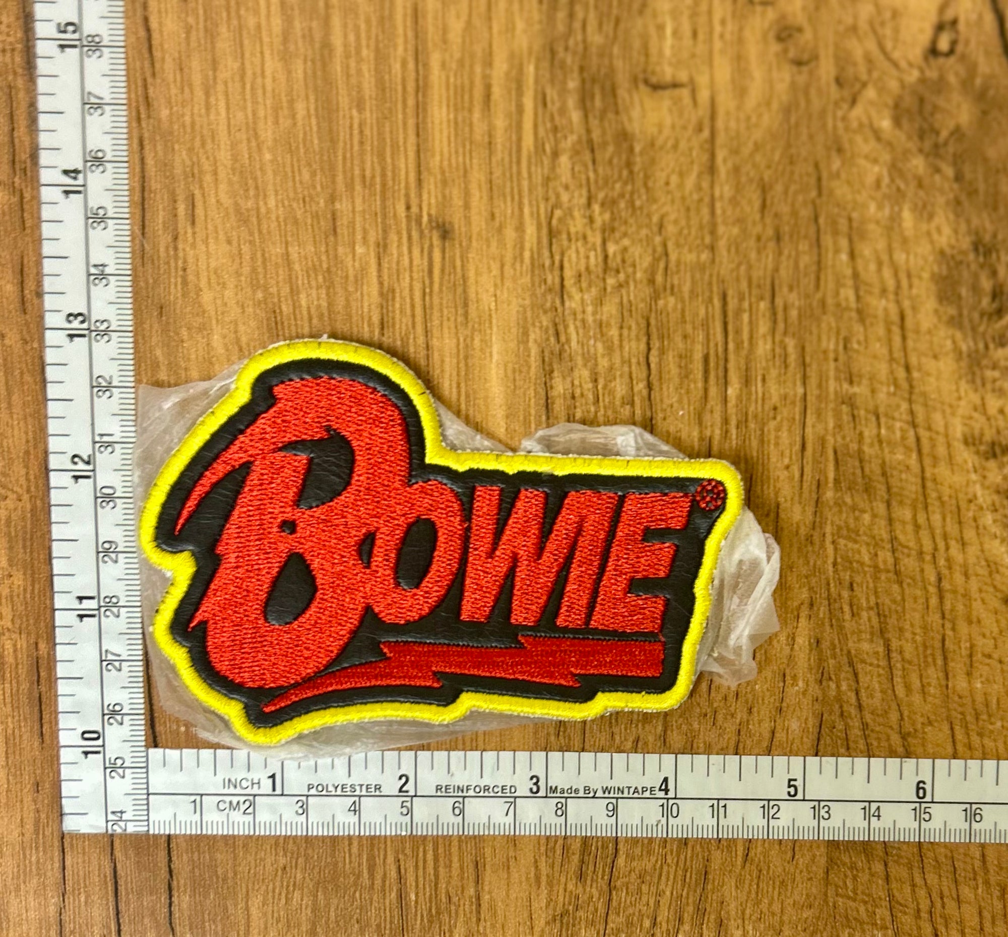 Close-up of The Mad Hatter Company Bowie patch with detailed embroidery and vibrant colors on a neutral background