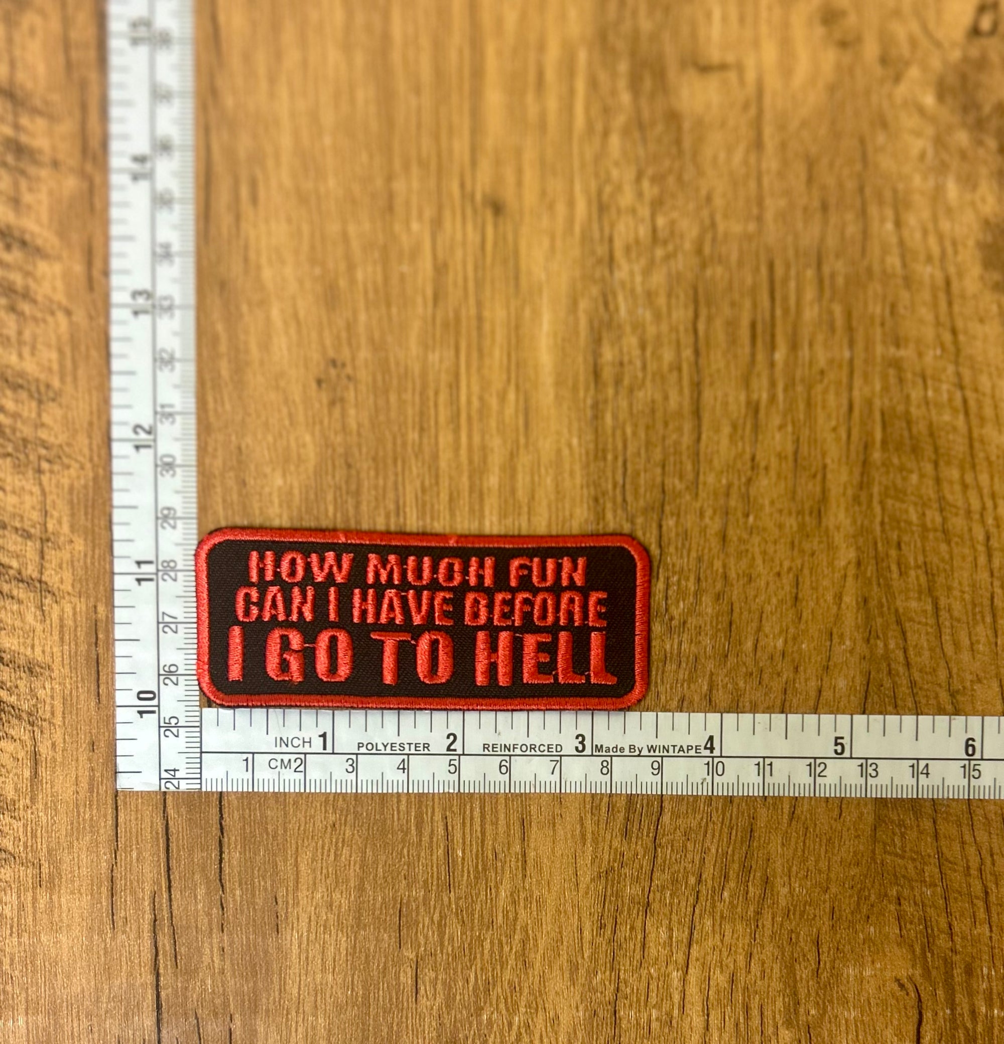 Black embroidered patch with "I go To Hell" text by The Mad Hatter Company, featuring bold lettering and detailed stitching.