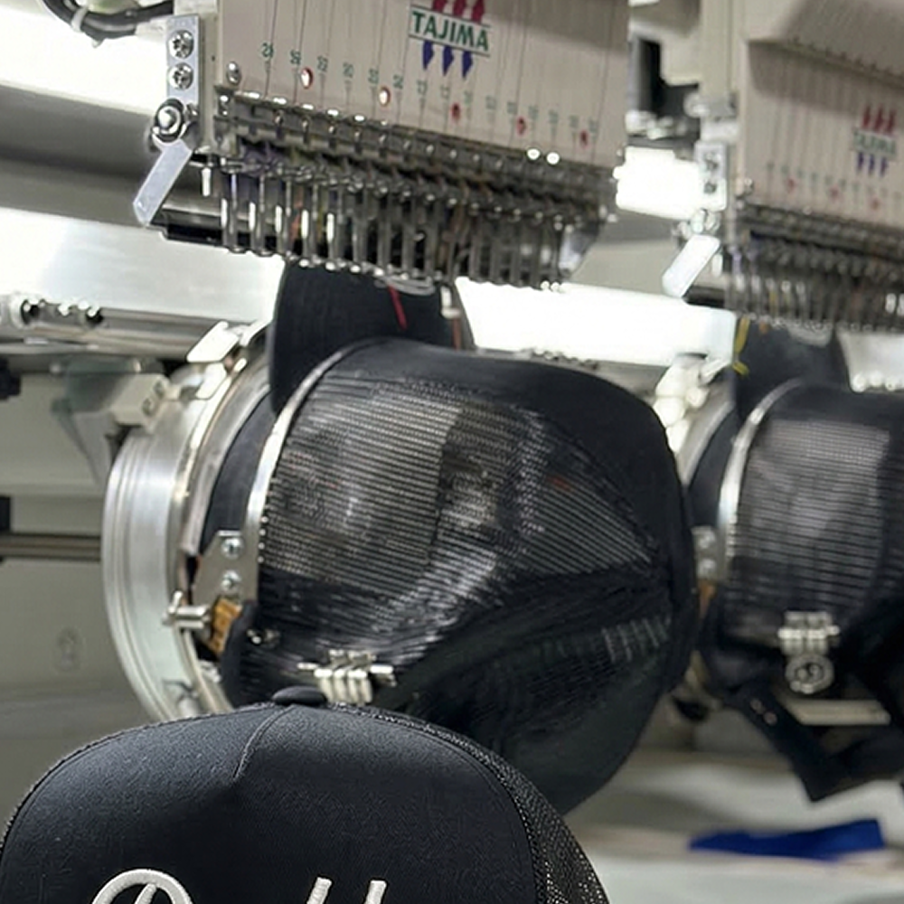 Tajima embroidery machine stitching trucker hats in the Mad Hatter Co. Georgia facility