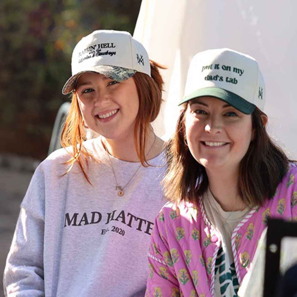 Two Mad Hatter Co. team members smiling in Mad Hatter hats